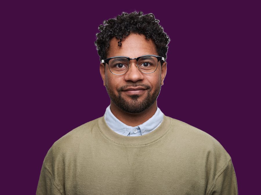 A portrait on a Purple ground: natural expression, restrained lighting, and no heavy styling, so the focus stays on the person